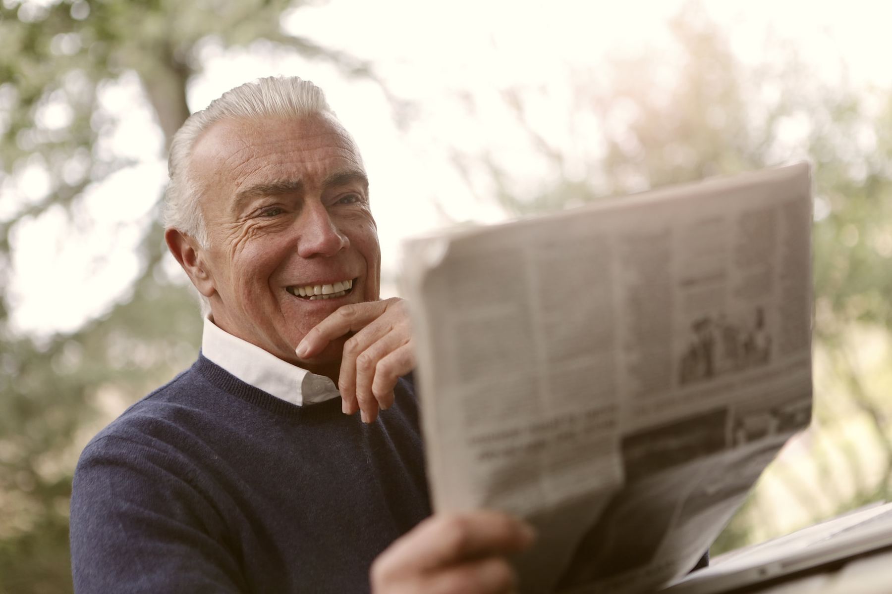 elderly man reading newspaper